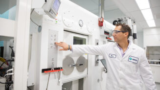 The head of Translational Imaging Biomarkers at Merck operating a machine that synthesizes alpha-synuclein tracers