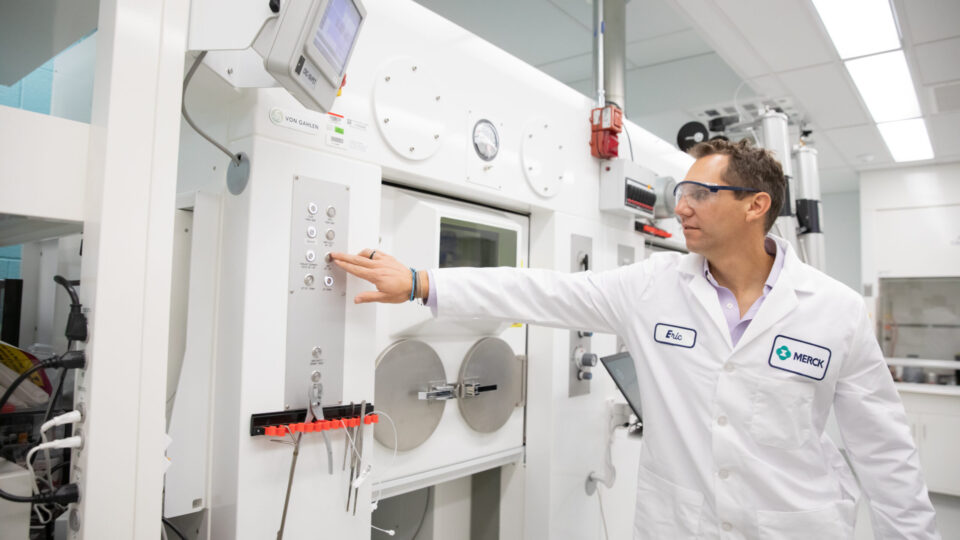 The head of Translational Imaging Biomarkers at Merck operating a machine that synthesizes alpha-synuclein tracers